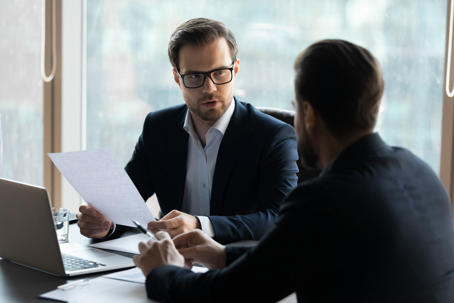 two men talking in a corporate office